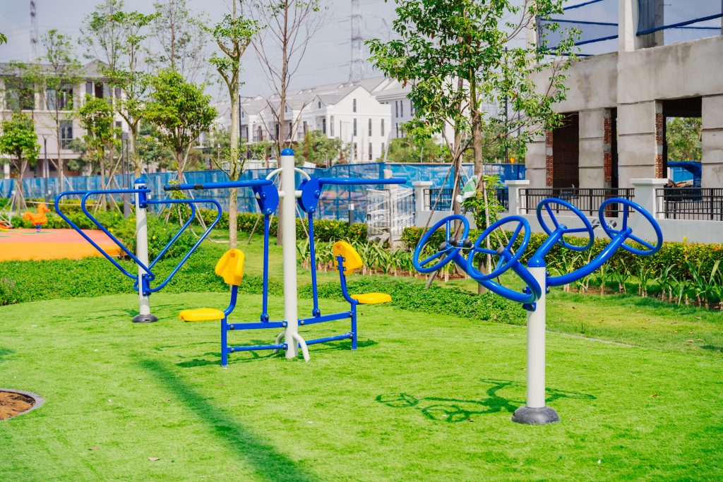 Outdoor playground with slides and climbing units on coloured rubber surfacing at GS Metro City