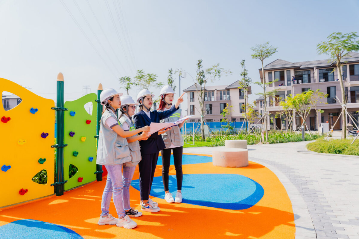 Children playing on seamless orange and blue EPDM rubber safety surfacing at a TNTY playground