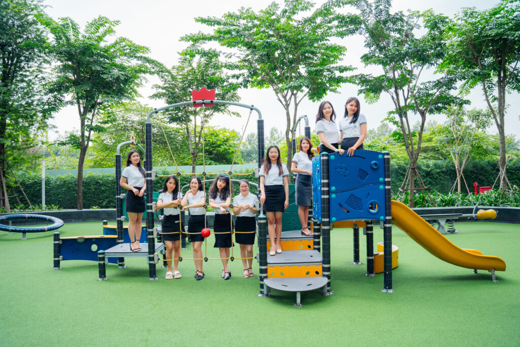 Combination playground unit with yellow slide, climbing panels and in-ground trampolines